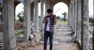 (ФОТО+ВИДЕО) Момче свири на виолина додека се пука во Мосул